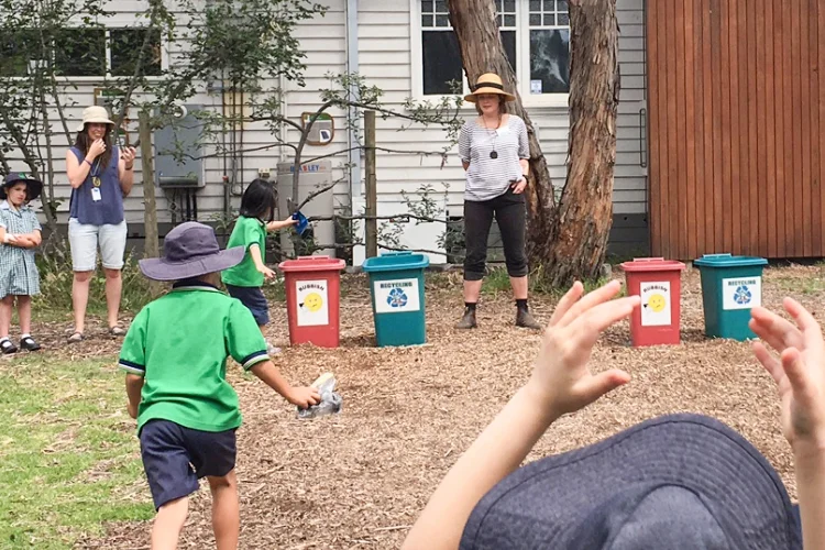 Students racing in a game to sort waste into correct bin