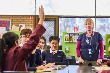 Student has her hand up in a classroom